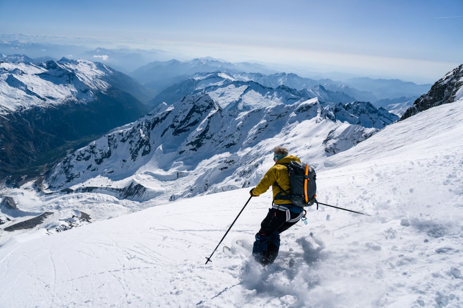 Sciatore in discesa nella neve fresca sopra la valle