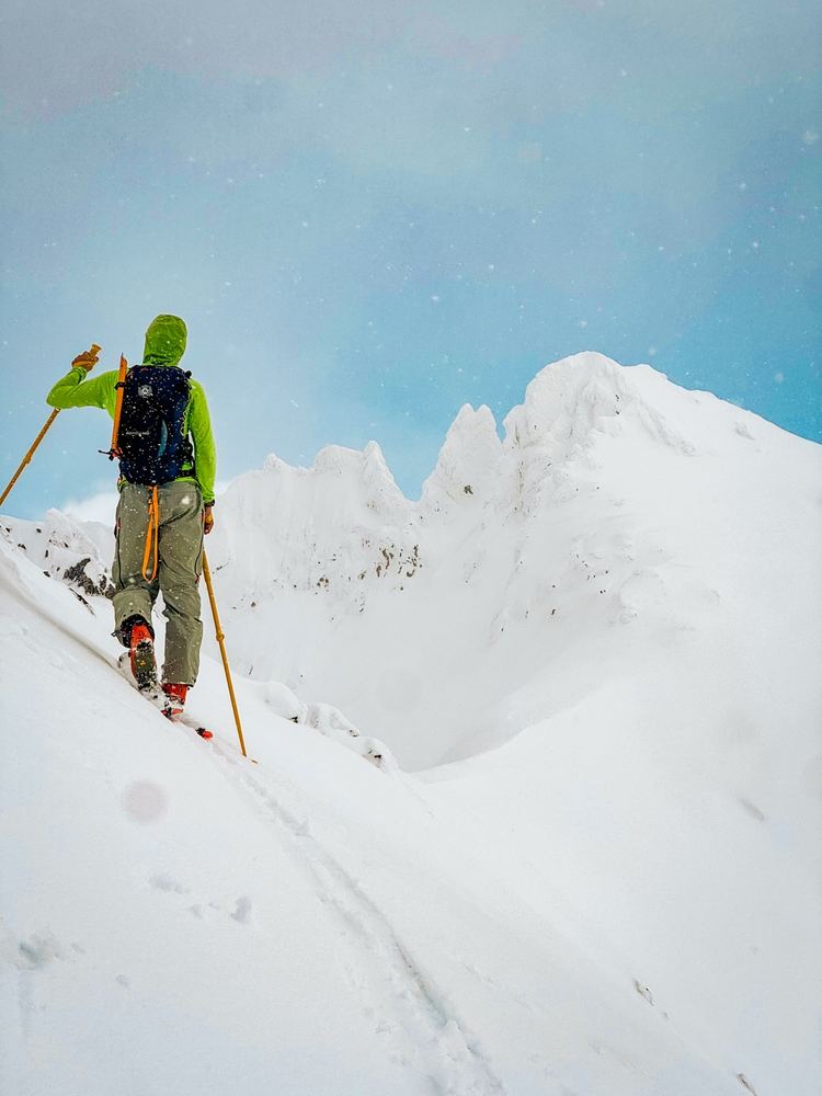 Sciatore in salita verso la cima innevata