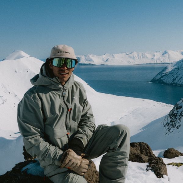 Enrico Veronese in sosta su una roccia, fiordo innevato alle spalle