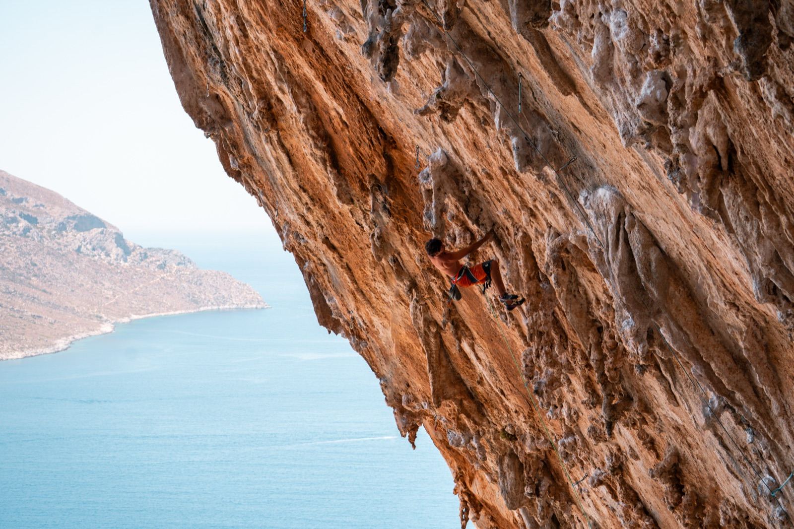 Arrampicata su parete di calcare arancione a picco sul mare, Kalymnos